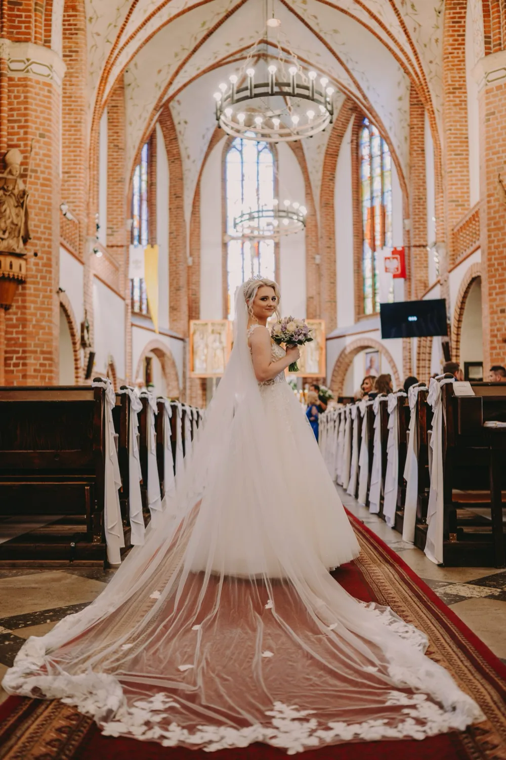 Panna młoda w nawie głównej kościoła - kadr wykorzystujący architekturę wnętrza